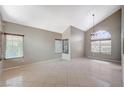 Bright living room featuring tile flooring, tall vaulted ceilings, and ample natural light from large windows at 5609 Indian Ridge Dr, North Las Vegas, NV 89031