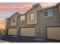 View of townhome garages with neutral paint, offering ample parking and storage space in a well-maintained community at 6807 Satin Silver Ct, North Las Vegas, NV 89086