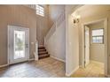 Bright foyer boasts tile flooring, a decorative glass door, and staircase leading to the second level at 741 Flowing Meadow Dr, Henderson, NV 89014