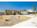 Single story home with desert landscaping, two car garage, and driveway with room for multiple vehicles at 7701 Pheasant Ln, Las Vegas, NV 89145