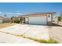Single story home with two car garage and desert landscaping at 7701 Pheasant Ln, Las Vegas, NV 89145