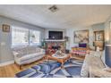 Cozy living room featuring a stone fireplace, comfortable seating, and natural light through large windows at 7961 Lions Rock Way # 202, Las Vegas, NV 89128