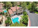 Stunning aerial view of the home with a private pool, lush landscaping, and a charming neighborhood at 7988 Pinnacle Peak Ave, Las Vegas, NV 89113
