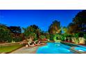 Inviting backyard oasis with a large pool, lush greenery, and comfortable lounge chairs for relaxation at 7988 Pinnacle Peak Ave, Las Vegas, NV 89113