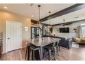 A kitchen features a kitchen island with seating, an adjacent living room, and modern stainless steel appliances at 8121 Russell Creek Ct, Las Vegas, NV 89139