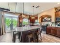 A well-lit kitchen offers a granite-topped island, stainless steel appliances and a view of the outdoors at 8121 Russell Creek Ct, Las Vegas, NV 89139