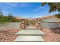 Wrought iron gate leading to a desert landscaped single story home with a terracotta roof at 9025 S Tenaya Way, Las Vegas, NV 89113