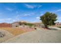 Single story home with a desert landscape, steps leading to the front gate, and a driveway leading to a garage at 9025 S Tenaya Way, Las Vegas, NV 89113