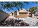 A single-story home with a one-car garage, neutral trim, and desert landscaping, shaded by a mature tree with a long driveway at 1905 Eskam St, Las Vegas, NV 89156