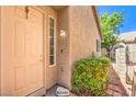Inviting front door with a welcome stone, trimmed window, and green landscaping at 201 Teller St, Henderson, NV 89074