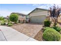 Inviting home with a brick driveway, lush landscaping, and a two-car garage at 2207 Valdina St, Henderson, NV 89044