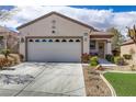 Home exterior with a large garage, nice driveway, and appealing desert landscaping at 2537 Nashira St, Henderson, NV 89044