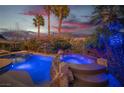 Backyard oasis featuring a pool and spa with stone accents, surrounded by lush landscaping and palm trees at 340 Autumn Palace Ct, Las Vegas, NV 89144