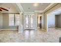 Open-concept living room with tile floors, columns, neutral colors, and lots of natural light at 4750 Fiore Bella Blvd, Las Vegas, NV 89135