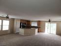 Open-concept living room with the kitchen in the background and ceiling fans at 5052 Whistling Acres Ave, Las Vegas, NV 89131