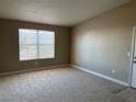 Spacious carpeted living room featuring neutral paint, trim and ample natural light from a large window at 5055 W Hacienda Ave # 2102, Las Vegas, NV 89118