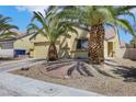 Inviting single-story home featuring palm trees, a two-car garage, and low-maintenance desert landscaping at 520 Blackbird Knoll Ct, North Las Vegas, NV 89084