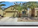 Charming single-story home with a two-car garage, featuring palm trees and low-maintenance desert landscaping at 520 Blackbird Knoll Ct, North Las Vegas, NV 89084