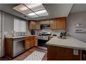 Well-equipped kitchen featuring stainless steel appliances, wood cabinets, and a skylight at 573 Sellers Pl, Henderson, NV 89011