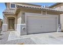 Close up of two-story home with a tile roof, a two-car garage, and neutral color scheme at 5834 Autumn Harvest Ave, Las Vegas, NV 89142