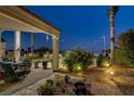 Cozy outdoor seating area with beautiful desert landscaping and ambient string lights at 6140 Galileo Dr, Las Vegas, NV 89149