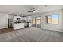 Open-concept living room featuring a bright kitchen and sliding glass doors at 6185 Blood Lily Ave, Las Vegas, NV 89122