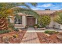 Inviting front entrance with a brick walkway and meticulous desert landscaping leading to the front door at 6405 Break Point Ave, Las Vegas, NV 89130