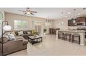 Open concept living room featuring tile floors and a dining area near a kitchen island with bar stool seating at 6788 Sharks Bay Ct, Las Vegas, NV 89149