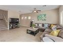 Spacious living room with tile floors, a ceiling fan, a large sectional, and a coffee table at 6788 Sharks Bay Ct, Las Vegas, NV 89149