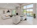 Bright, open living area featuring high ceilings, a modern fireplace, and large windows overlooking the pool at 7062 Maverick St, Las Vegas, NV 89131