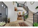 Bright foyer with tile flooring, a staircase with wrought iron railing, and views to other rooms at 7621 Hackensack Ct, Las Vegas, NV 89128
