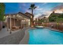 Backyard with a beautiful private pool, spa, covered patio, and desert landscaping at 7621 Hackensack Ct, Las Vegas, NV 89128