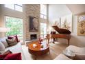 Bright living room boasts a stone fireplace, hardwood floors, and a grand piano, creating a stylish atmosphere at 794 Oakmont Ave # 106, Las Vegas, NV 89109