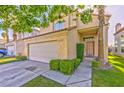 Inviting home featuring a two-car garage, green shrubbery and well maintained lawn at 8231 Burnt Sienna St, Las Vegas, NV 89123