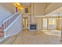 Spacious living room featuring tile floors, fireplace, and an open staircase at 8231 Burnt Sienna St, Las Vegas, NV 89123