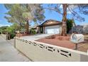 Well-kept home featuring a spacious driveway and mature landscaping, enhancing its curb appeal at 872 N Linn Ln, Las Vegas, NV 89110