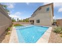 Inviting backyard pool and spa, perfect for relaxation and entertaining with a paved deck and privacy fence at 9839 Berkley Brook Ct, Las Vegas, NV 89141