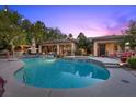 Resort-style backyard featuring a sparkling pool, spa, covered patio, and ample seating areas at 10674 Chillingham Dr, Las Vegas, NV 89183