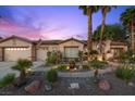 Inviting desert home with a well-manicured front yard, mature palm trees, and a two-car garage at 10674 Chillingham Dr, Las Vegas, NV 89183