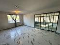Bright living room featuring marble-like tile flooring and a sliding glass doors opening to an enclosed patio at 1304 Bonita Ave, Las Vegas, NV 89104