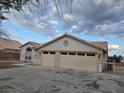 A neutral stucco home featuring a tile roof, an attached two-car garage, and a concrete driveway at 1345 N Hollywood Blvd, Las Vegas, NV 89110