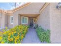 Inviting front entrance with a charming walkway, colorful flowers, and neutral exterior at 155 Fallon Dr, Henderson, NV 89074
