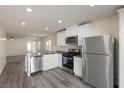 Modern kitchen featuring stainless steel appliances, white cabinets, and a view into the adjacent living area at 1716 Desert Path Ave, North Las Vegas, NV 89032