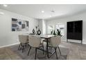 Bright dining room with modern decor, stylish table setting, and view to green space at 4039 Beech Fern Ave, North Las Vegas, NV 89084