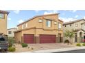 Two-story home with a tan exterior, three car garage, desert landscaping and brick driveway at 4039 Beech Fern Ave, North Las Vegas, NV 89084