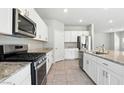 Well-equipped kitchen featuring modern appliances, granite countertops, and ample cabinet space at 4039 Beech Fern Ave, North Las Vegas, NV 89084
