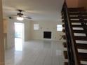 Bright living room features tile flooring, a ceiling fan, and a cozy fireplace at 5006 Schumann Dr, Las Vegas, NV 89146