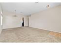 Bright, open-plan living room featuring neutral carpet and a view of the kitchen area at 5307 Wild Orchid St, North Las Vegas, NV 89031