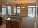 Open-concept living space filled with natural light, carpet, and a sliding door to backyard at 5307 Wild Orchid St, North Las Vegas, NV 89031
