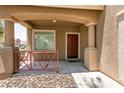 Inviting front porch with a red door and decorative metal railing at 5835 Running Horse Dr, North Las Vegas, NV 89081